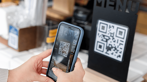 Customer scanning QR code at a restaurant to place order from mobile phone